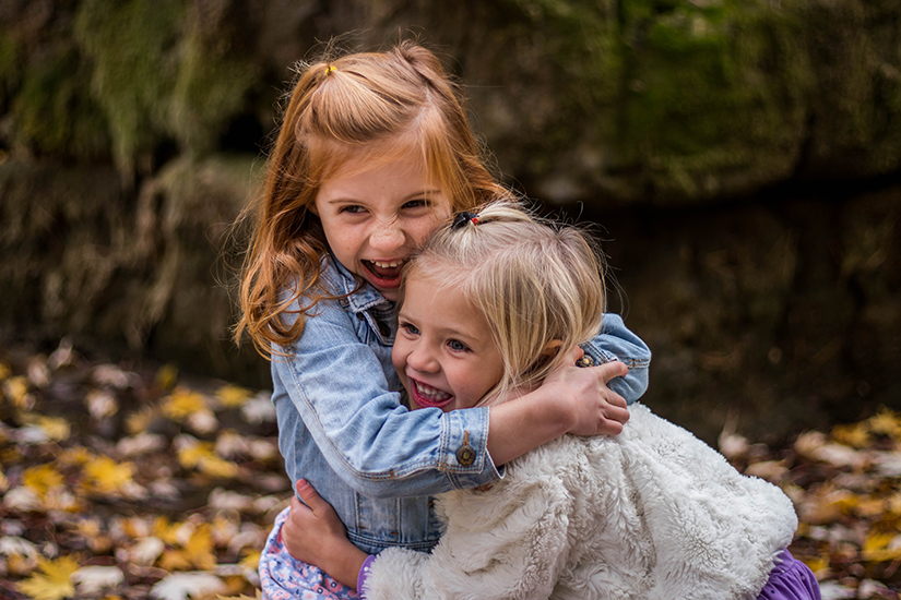Zwei junge Mädchen, die sich innig umarmen und dabei lachen